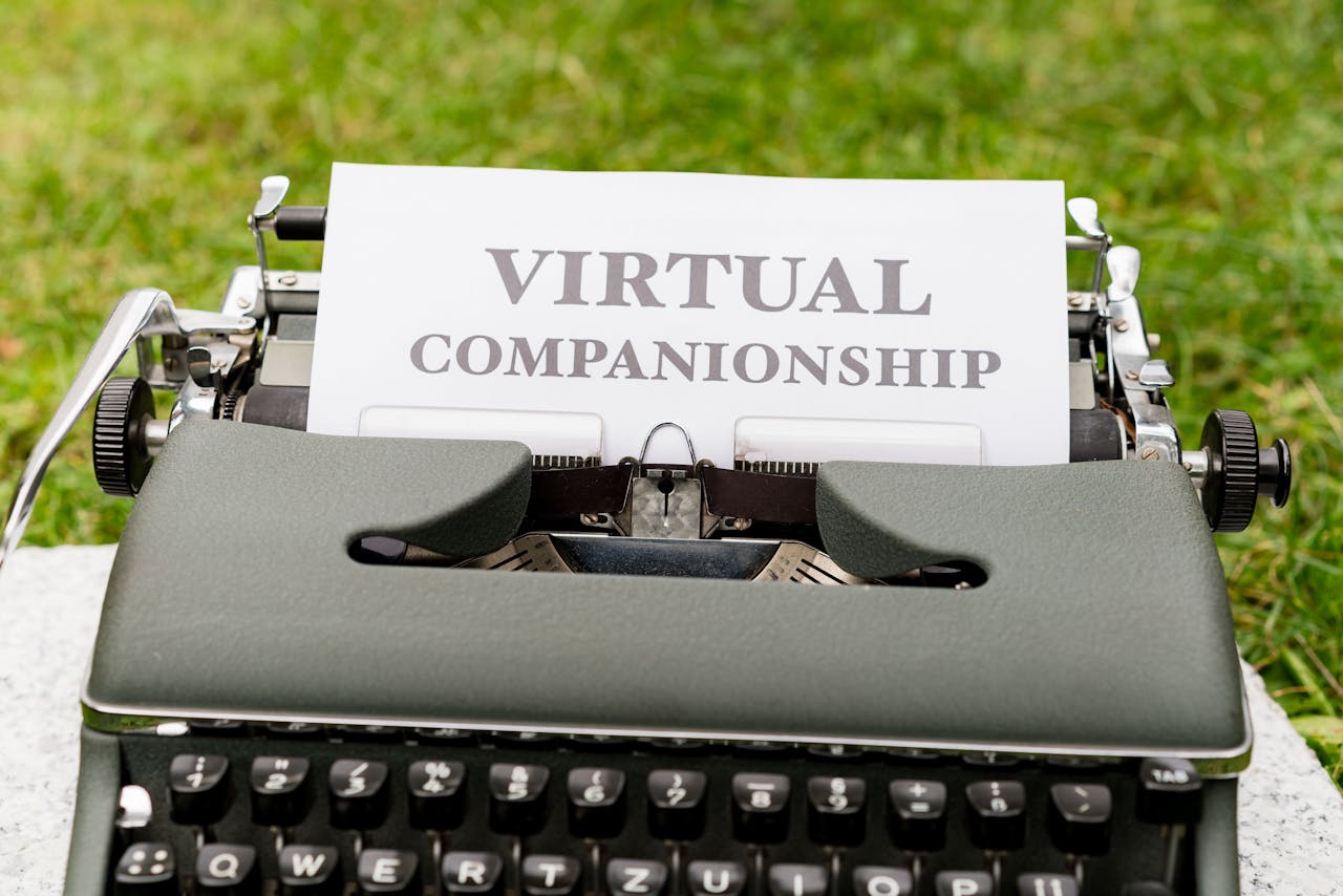 Typewriter on grass with paper showing text Virtual Companionship.